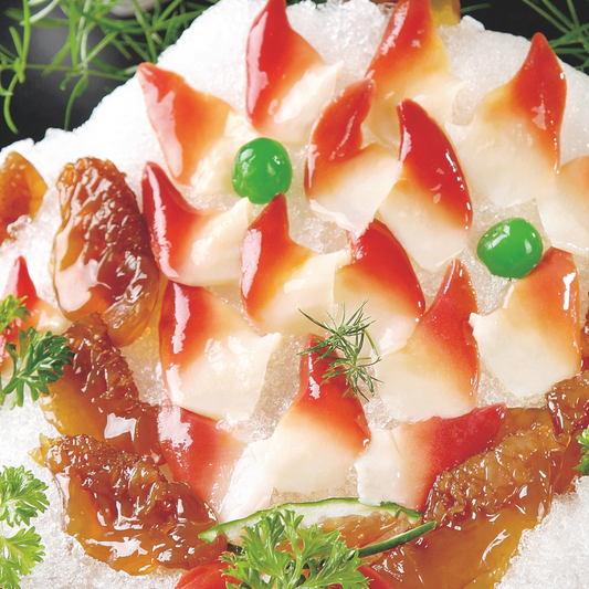 Hokkigai clams delicately arranged on a bed of ice, accompanied by colorful garnishes and green decorations.