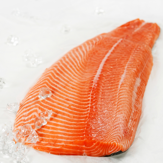 Fresh sashimi-grade Atlantic salmon fillet in Trim C cut, with beautiful visible fat marbling, displayed on a bed of ice against a clean white background