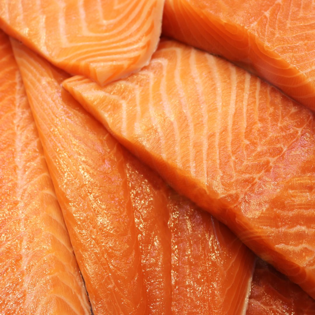 FFresh sashimi-grade Atlantic salmon fillet portion slices with vibrant pink-orange hue, showcasing freshness and premium quality.